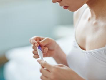 Todo sobre la ovulación: lo que necesitas saber Mujer joven comprobando un test de embarazo